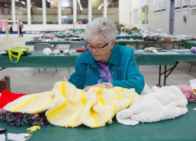 Marjorie Lane judges items in the knitting category during the Sundre School and Adult Fair at the Sundre Curling Club on Sept. 6.
