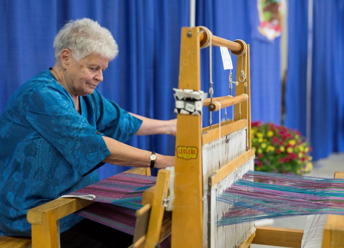  Ruth Hahn uses a weaving loom during the fall fair.