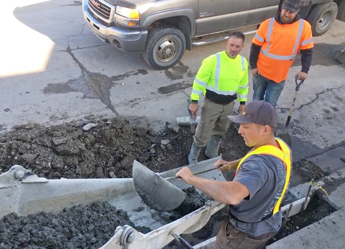  Another GrindStone crew works last week on repairing the curb and asphalt that connects Fourth Street SW with the parking lot access to several businesses including the grocery story.