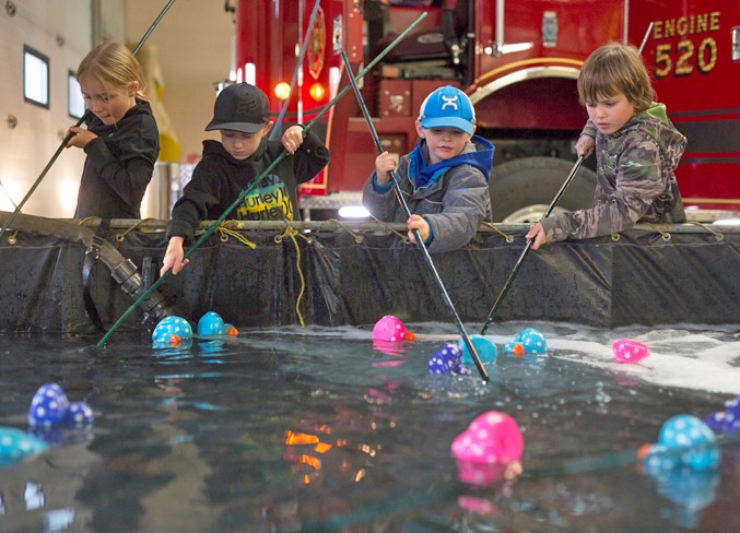  Children focus intently on fishing for rubber duckies in a temporary pool set up for the event.