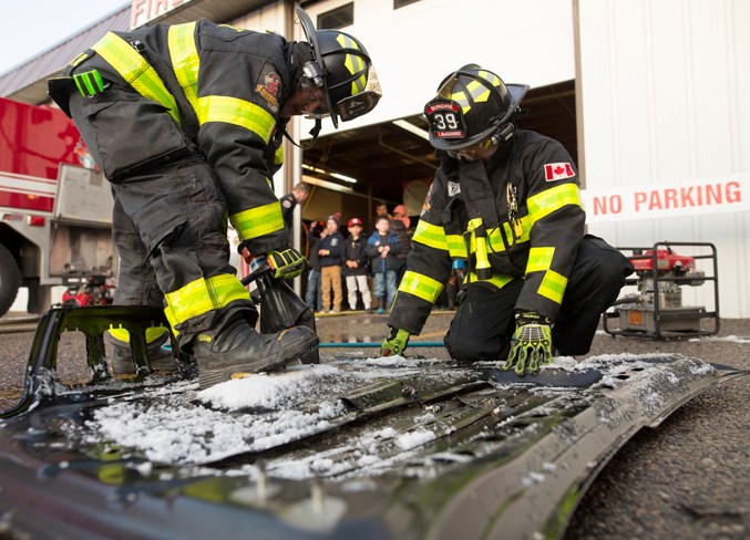  Sundre firefighter Cody McAllister, left, cuts a vehicle hood in half with the aid of Troy Blackhurst during an open house at the Sundre fire hall.