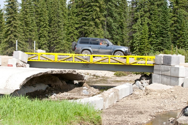 A vehicle passes over the temporary bridge on Rge. Rd. 52 last Tuesday.