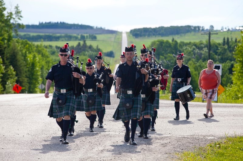 The Men of Vision Pipes and Drums from Cochrane march down the main drag of Water Valley.