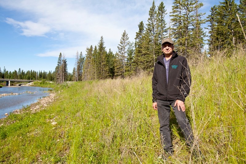 Bryce Schacher stands on the berm on his property north of the Little Red Deer Store in Westward Ho.