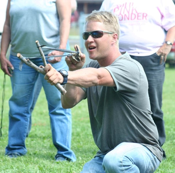 A mountain man competition participant loads his slingshot during the target-shooting event.