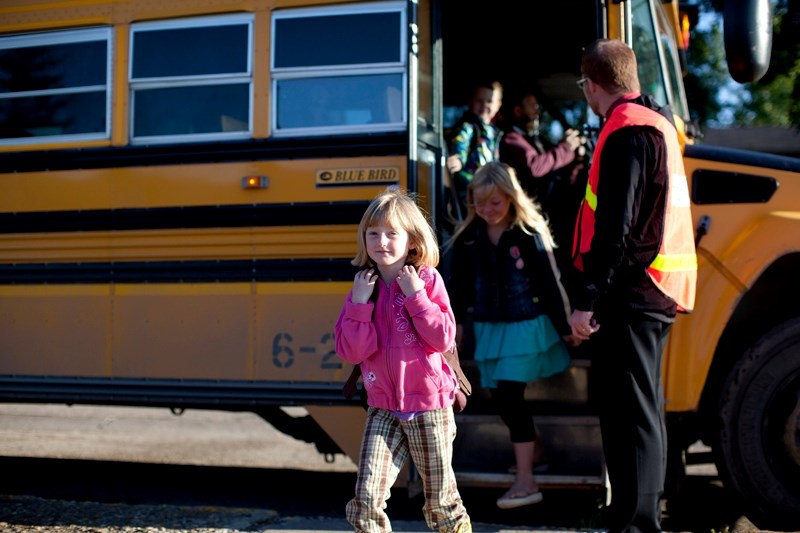 Students exit the bus at Olds Elementary School.