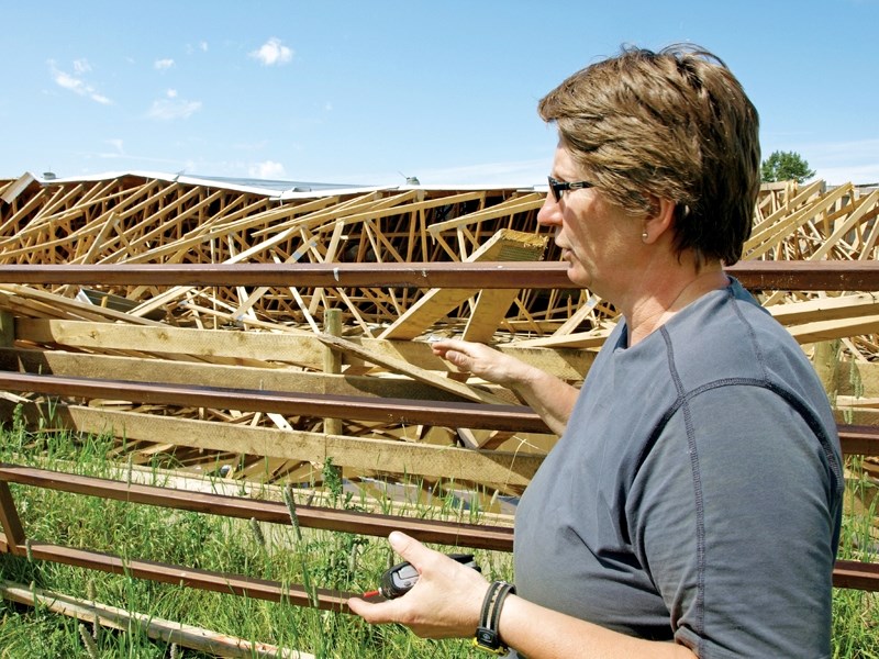 Monica Kaban stands outside her riding arena in July just a week after she witnessed a tornado begin to destroy her property.