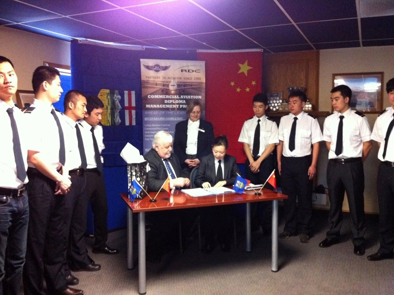Lisa Gong of China Flying Dragon Aviation and Dennis Cooper of Sky Wings Aviation Academy sign a contract during a March 14 ceremony that will see 200 Chinese aviation