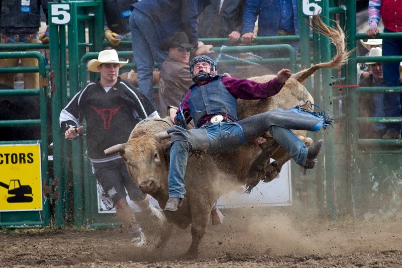 Troy Dell of Cochrane winces with pain after getting caught up during his run in the bull riding event of the Water Valley Rodeo on Saturday June 2. For more photos see the