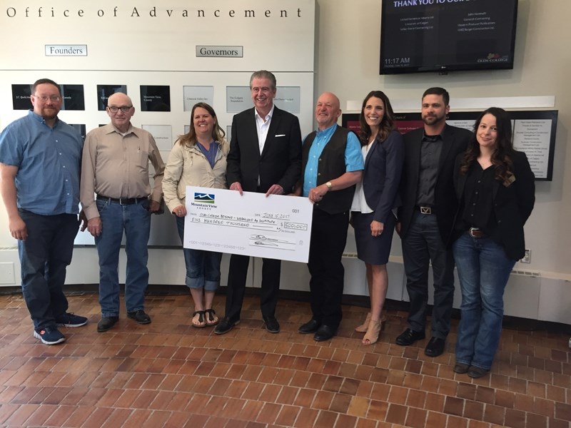 Olds College president H.J. Thompson, fourth from left, and vice-president of advancement Tanya McDonald, third from right, accept a $500,000 cheque from Mountain View