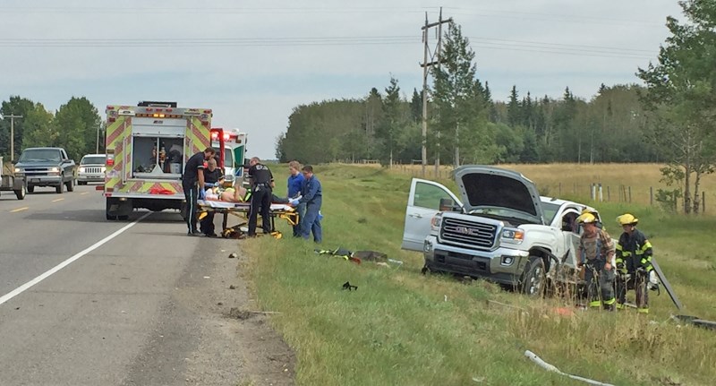 EMS personnel and Sundre firefighters assist the injured driver of one of two vehicles involved in collisoin on Highway 27 on Friday afternoon.