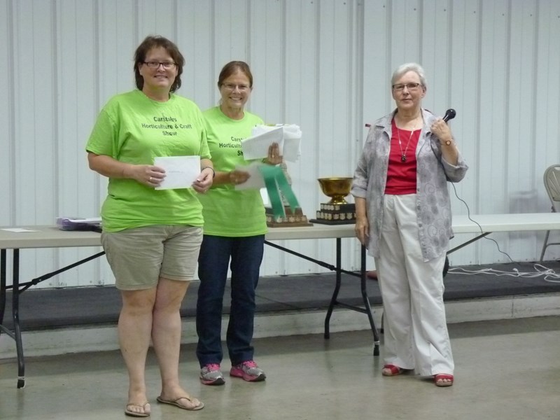 Tracey Colosino, left, accepts congratulations from committee chair Paige Gil, centre, and MC Gwen Jensen, right, after winning the top points in show ribbon at the recent