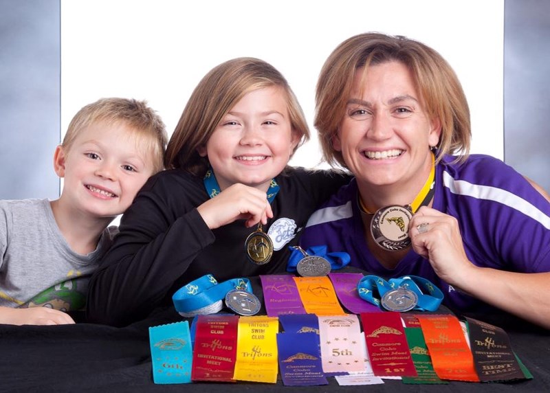 Didsbury Aquajets coach Cecilia Wessels, far right, and daughter Cheye-Anne Wessels (plus TJ) show off a couple of their favourite ribbons and medals from the recently