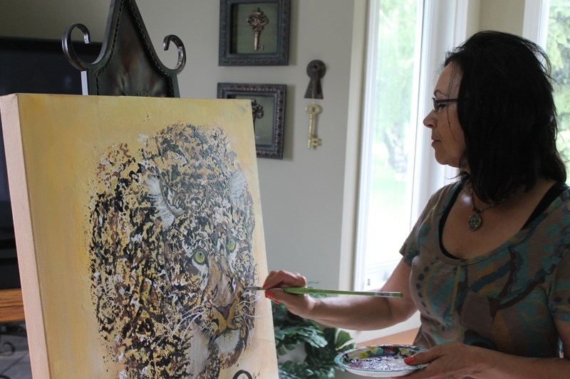 Innisfail artist Dustine Kinsella works on a painting.