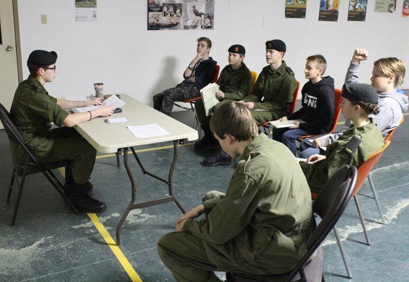 Sgt. Josh Boyd, left, instructs cadets on using maps and other outdoor survival techniques during parade night for the 3025 Didsbury Army Cadets on Jan. 11 at the Victoria