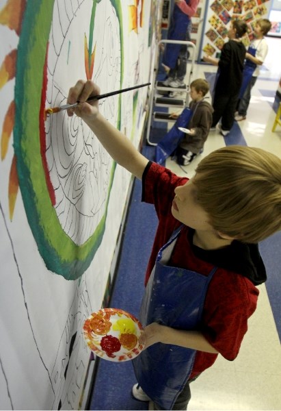 Grade 4 students from école John Wilson Elementary School work on the wall mural in one of the second story hallways of the school on Friday, Feb. 4.