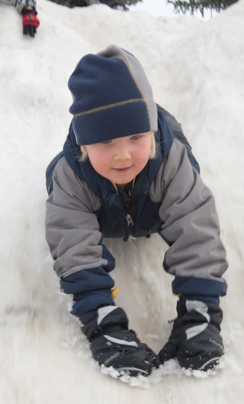 Colby LaRoy takes advantage of a snowbank to slide down Friday afternoon.