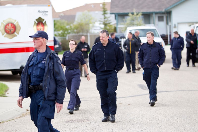 Police gather around a residence in Innisfail Friday morning as part of an ongoing criminal investigation.