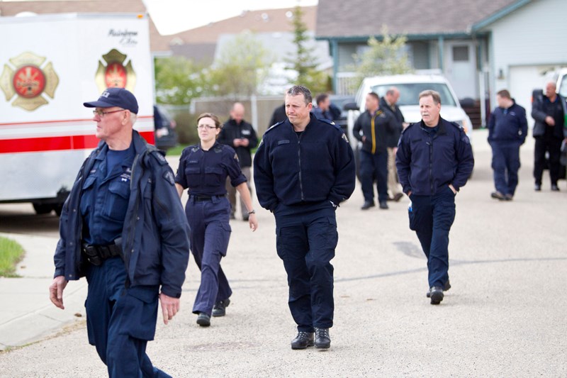 Police gather around a residence in Innisfail Friday morning as part of an ongoing criminal investigation.