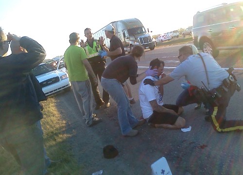 Officers attend the scene of a Sept. 20 fight on the side of the highway just north of Bowden as first-aid is administered to the victim.