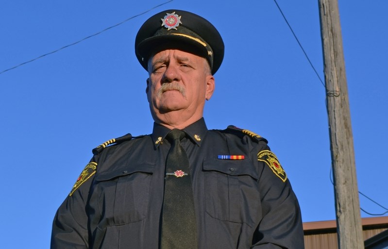 Bowden fire Chief Larry Werner under the pole for the town&#8217;s old fire siren.