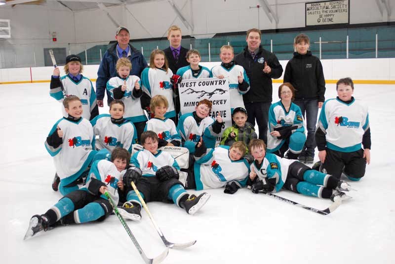 Players and coaches from the Bowden Atom Blades pose for a team photo with their banner after winning the league final on Tuesday, March 22, in Bowden.
