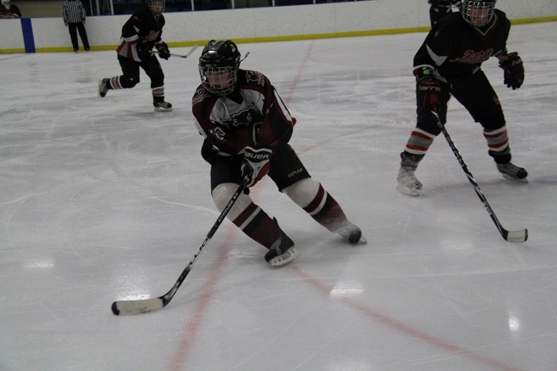 Cassidy Holt of the Central Alberta Amazons turns the puck away from a Fort Saskatchewan Fury player during the AJFHL Championships at the Penhold Regional Multiplex on March 