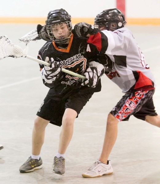 An Innisfail Phantoms player braces against a check from a Red Deer Chiefs opponent.