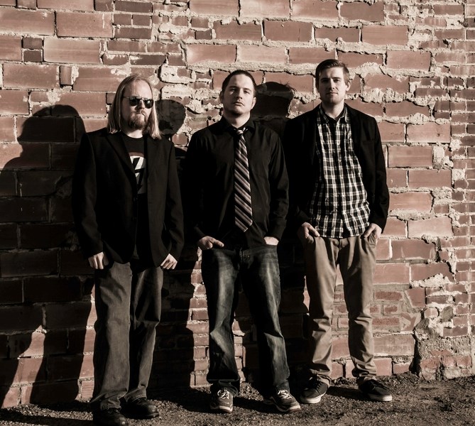 Local musician Lowell Van Carroll (centre) poses with band mates Dallas Lobb (left) and Brett Winnichuk (right).