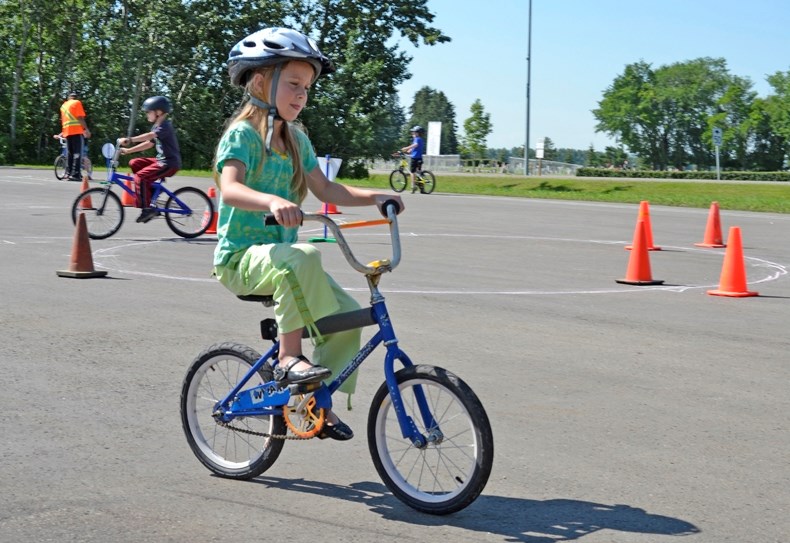 Penelope McPhail, 7, practices her newly taught safety tips at the bike rodeo.
