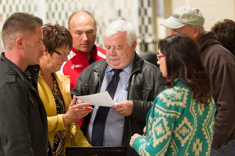 Penhold candidates huddled around Mayor Dennis Cooper to review the election results. Cooper was re-elected for a second term.