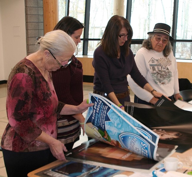 Innisfail Family Violence and Bullying Coallition members look at posters that will be displayed around town for National Bullying Awareness Week.