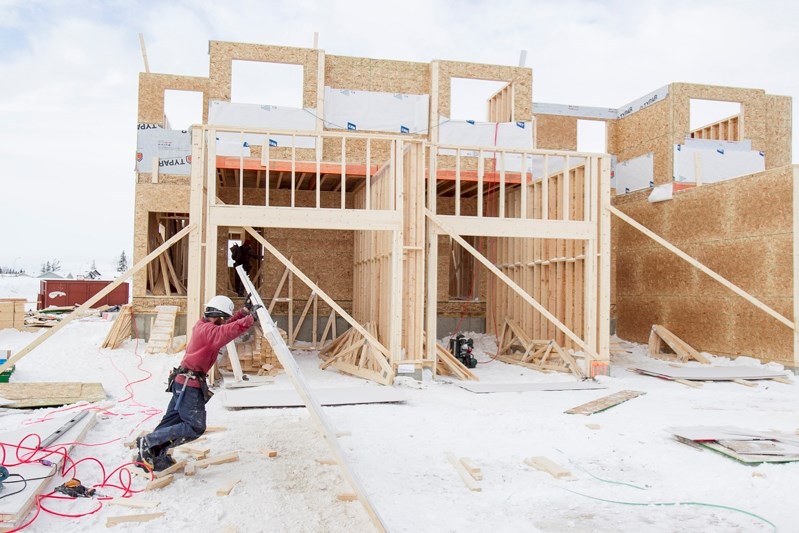 A construction crew works on a house across from the Penhold Multiplex on Jan. 9.