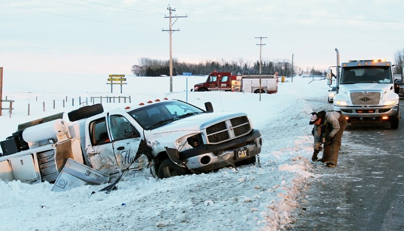 Worker cleans up an accident scene three kilometres west of Bowden on Highway 587 on Jan.9. Two victims was taken to hospital.
