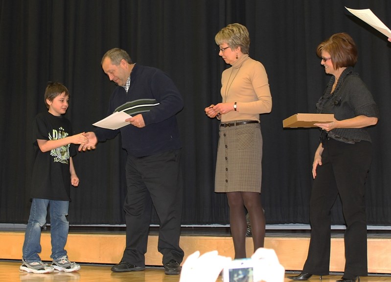 Isasc Ingram, Innisfail Middle School Grade 5 student, receives his DARE graduation certificate from Innisfail Mayor Brian Spiller while Diane MacKay, Red Deer Catholic