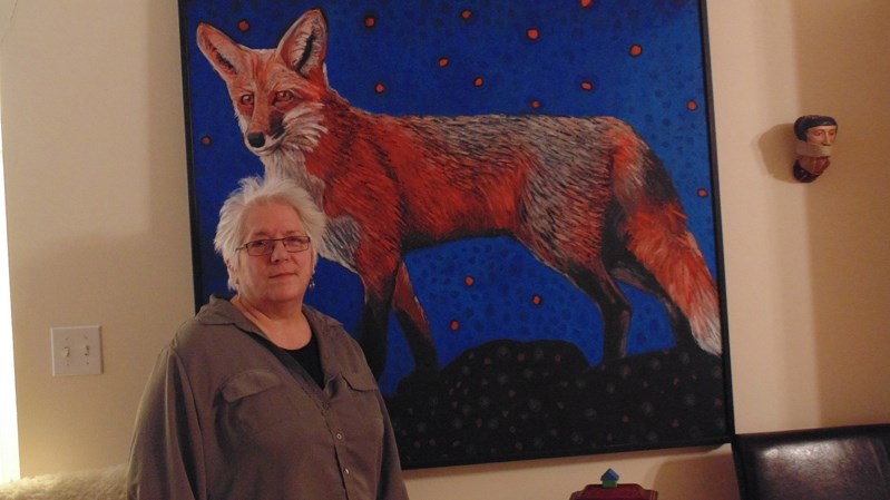 Artist Betty Spackman poses with one of her creations in her Innisfail home and studio.