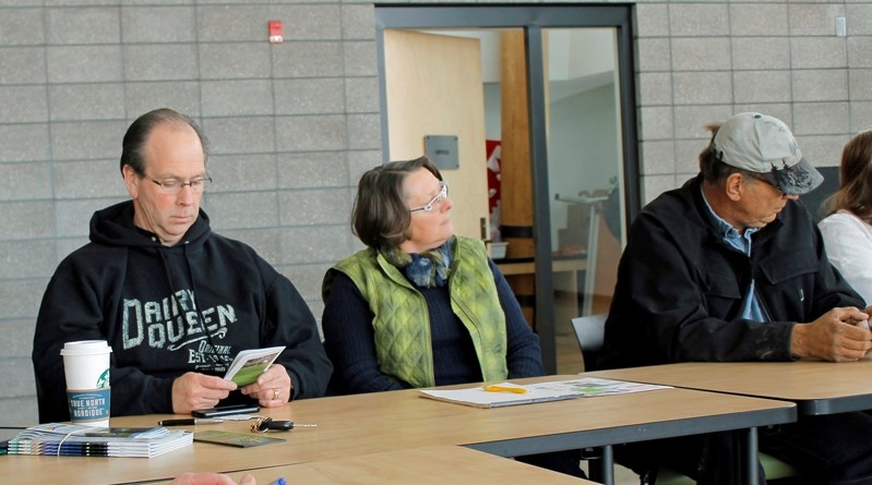 Mark Kemball (left) looks at the tentative Innisfail tourism brochure while Jose Hoppenbrouwers (middle), and Doug Bos (right) listen to discussion at the monthly tourism