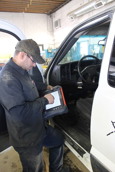 Jason Lazowski of OK Tire diagnoses a vehicle with equipment connected to the internet.