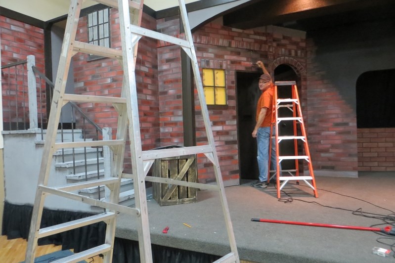 Ron Kooy paints the bricks on the set of Innisfail Town Theater&#8217;s upcoming production of Blood Brothers. The show opens April 24 at the Ol&#8217; Moose Hall.