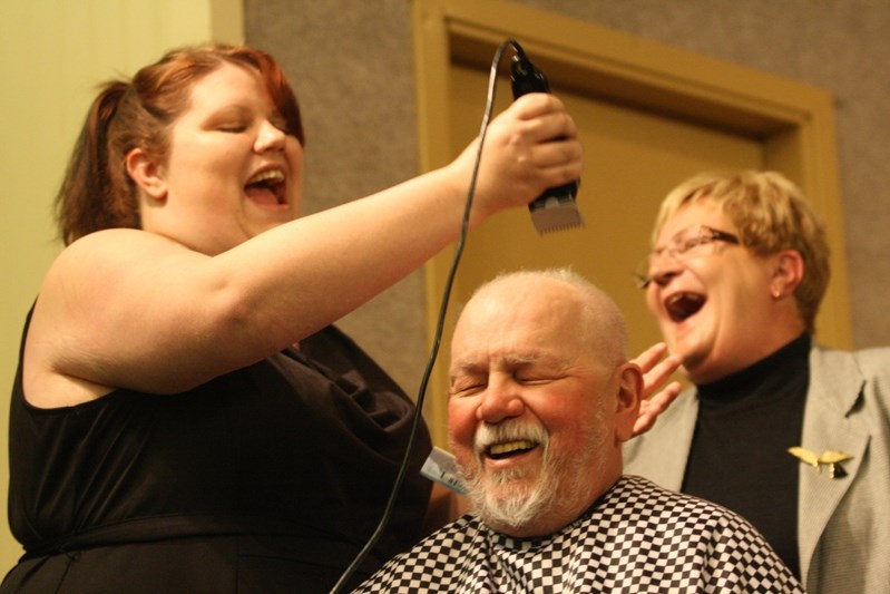 Trish King (left) and Evelyn Black (right) shave Innisfail Legion sergeant-at-arms Pat McAllister&#8217;s head at the 2013 Boob Tour comedy show in Innisfail to raise money