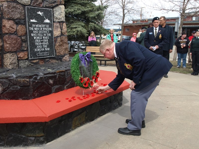Del Seabrook, president of Innisfail Royal Canadian Legion Branch 104, lays a poppy beside a wreath at the cenotaph during the May 9 National Day of Honour local ceremony for 