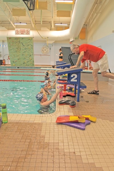 Coach Bill Culham of the Innisfail Dolphins Swim Club speaks to senior swimmers before they warm up in the Innisfail Aquatic Centre pool on May 7.