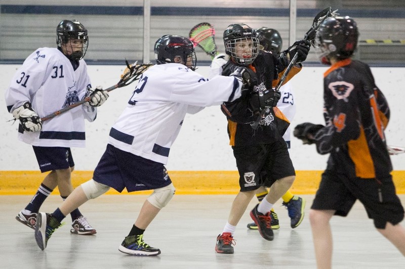 Innisfail Peewee Phantoms player Jaden Bowe gets checked by a Calgary Axeman player during their game.