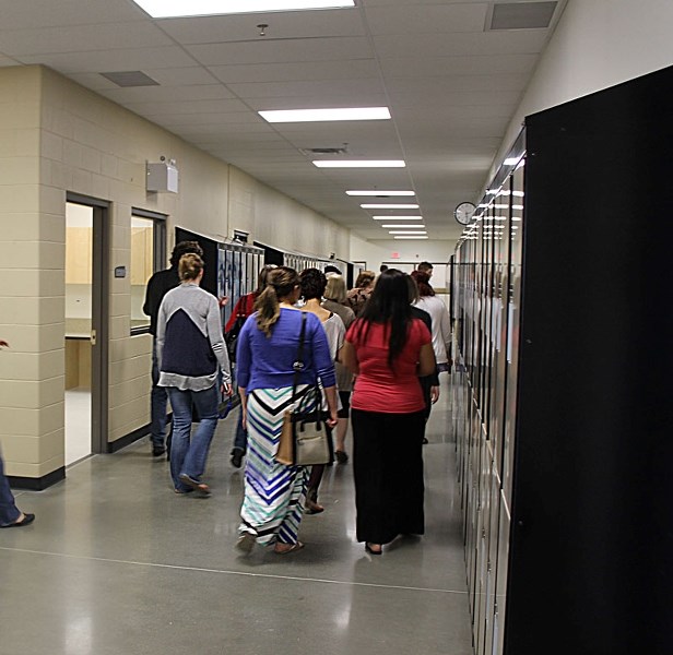Employees of the Town of Penhold walk through the halls as the soon-to-be opened Penhold Crossing Secondary School during the June 20 tour.
