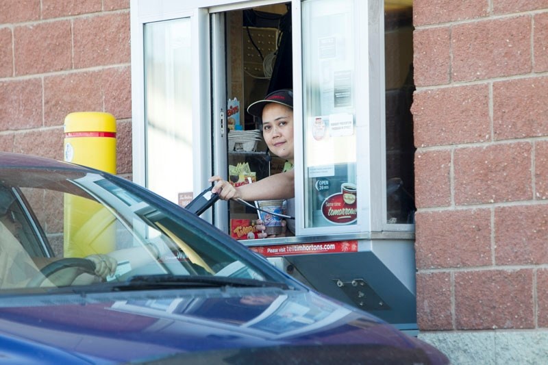 A foreign worker serves a customer at Innisfail Tim Hortons.