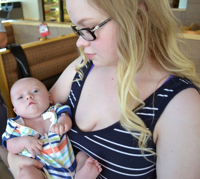 Innisfail&#8217;s Bailey Pickard shows five-month-old Henry Nathaniel Pickard&#8217;s scar from his July 3 open heart surgery.