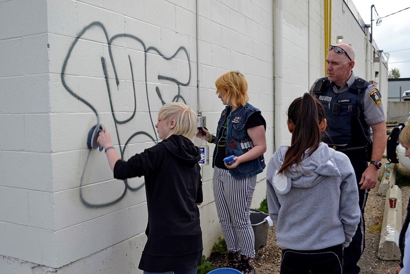 Innisfail youth clean grafitti off a business wall.