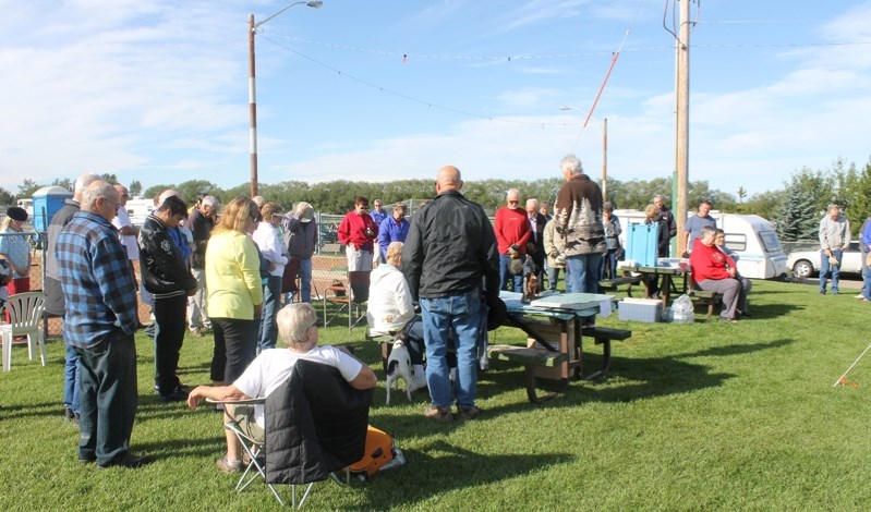 Members of the Alberta Horseshoe Pitch Association bow in silence to honour their &#8216;Angels&#8217;.