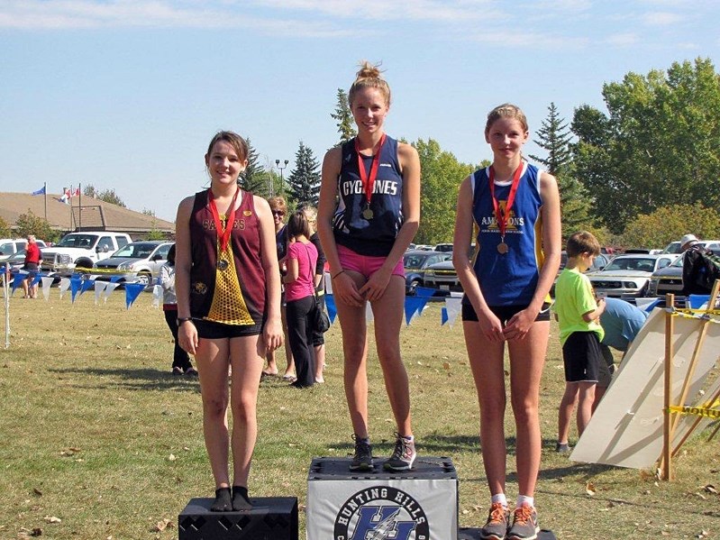 Emily Lucas (centre) stands tall waiting for her gold medal at her recent win at this year&#8217;s Red Deer Lightning Invitational XC Race.