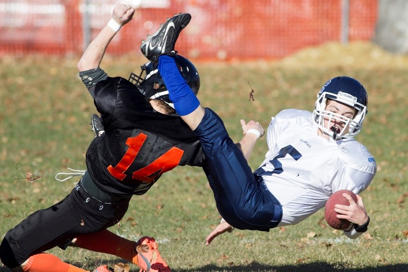 Innisfail Cyclones player Ward Marshall gets tackled by a Carstairs Tigers player during their playoff game in Innisfail on Oct. 18. The Cyclones won the game 52 to 8 and